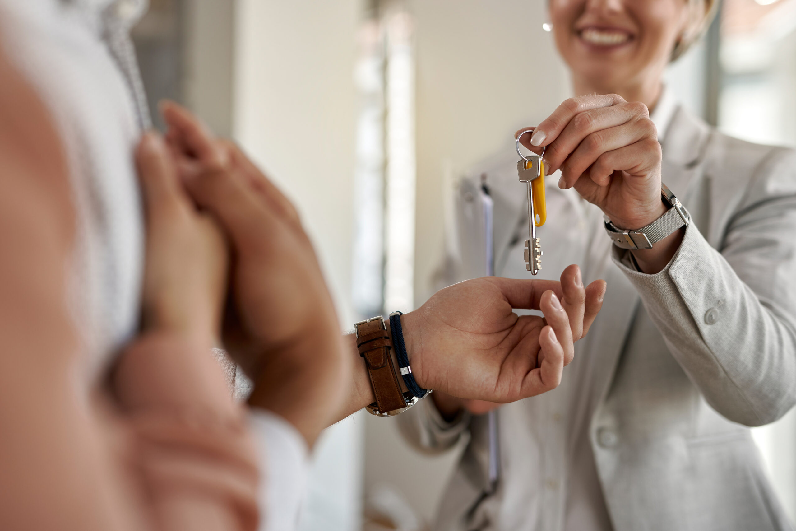 Close-up of real estate agent giving new house keys to a couple